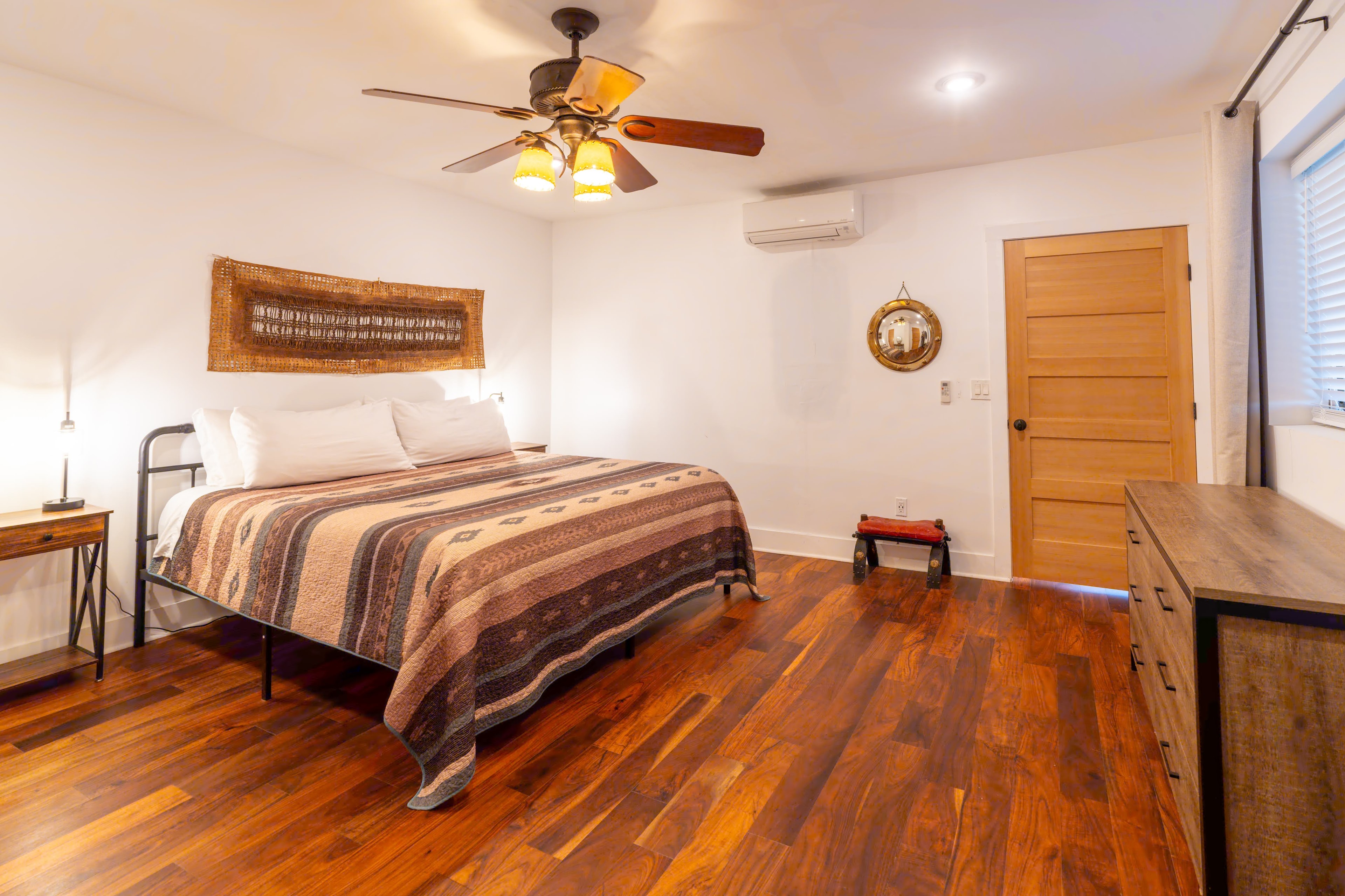 Spacious bedroom with wooden floors and ceiling fan