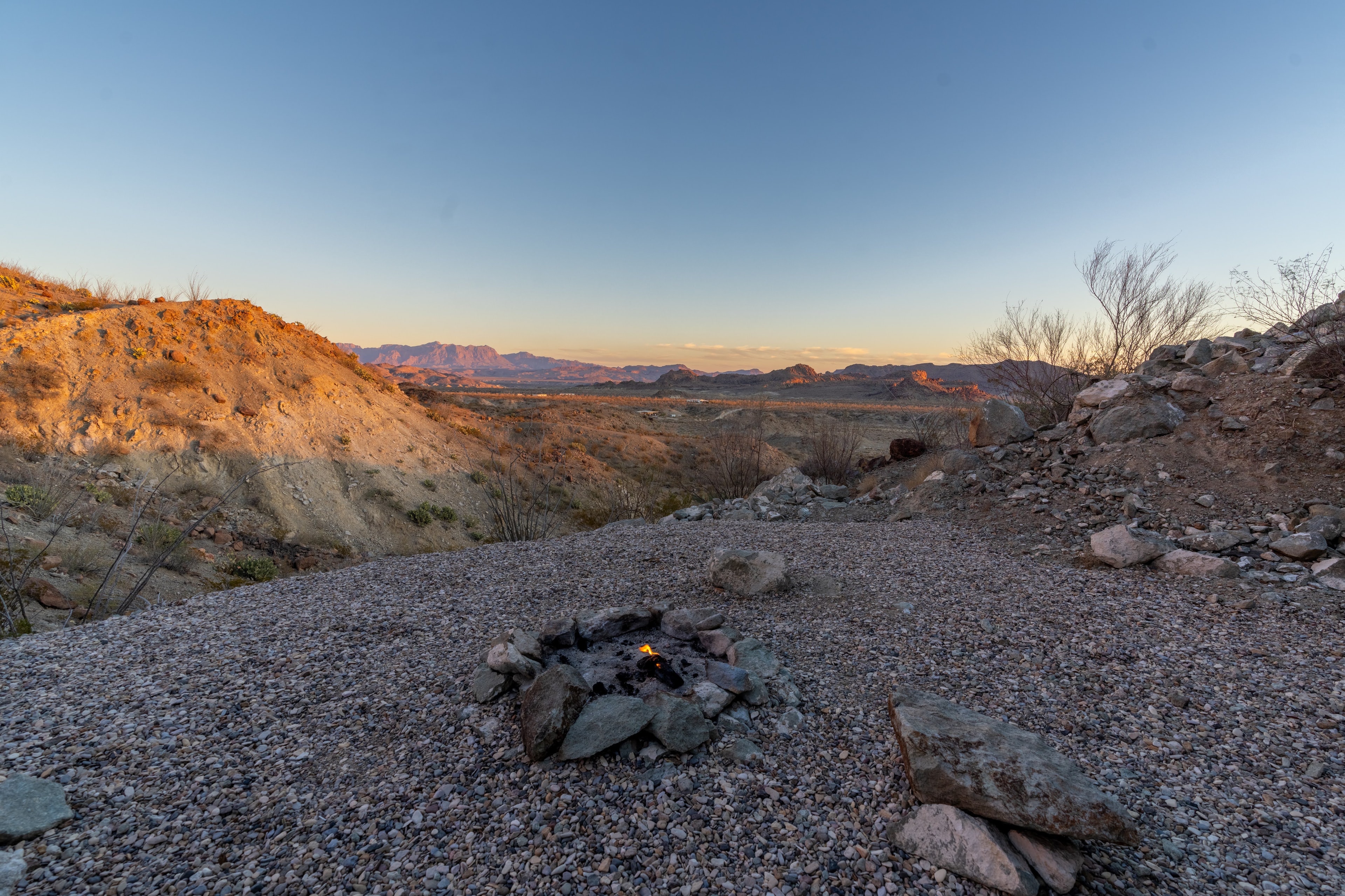 Campfire in desert landscape at dusk